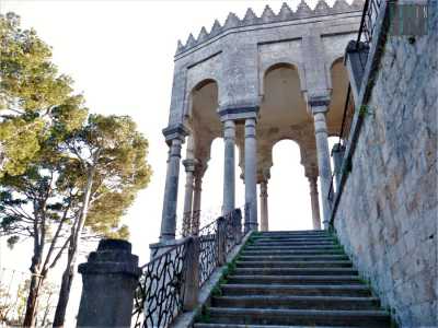 La facciata si caratterizza per una elegante scalinata laterale, percorsa da una ringhiera a motivi geometrici che si fa importante elemento decorativo e filo conduttore lungo la splendida balconata frontale